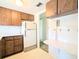 View of a kitchen with wood cabinets, white appliances, and a built-in wall desk with mushroom-themed tiling at 5901 Garden Ln # H23, Bradenton, FL 34207