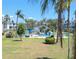 Community pool area surrounded by lush landscaping, palm trees, and low-rise condo buildings at 5901 Garden Ln # H23, Bradenton, FL 34207