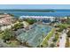 Waterfront living: aerial view of complex, tennis courts, landscaping, and beautiful bay views at 615 Dream Island Pl # 303, Longboat Key, FL 34228
