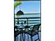 Charming balcony view with a dining table setup overlooking the serene waterfront and lush greenery beyond at 615 Dream Island Pl # 303, Longboat Key, FL 34228