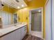 Bathroom with stylish vanity, mirror and a walk-in shower with a glass block wall at 615 Dream Island Pl # 303, Longboat Key, FL 34228