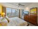 Bright bedroom with waterfront view, wood floors, ceiling fan, and large dresser at 615 Dream Island Pl # 303, Longboat Key, FL 34228