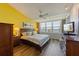 Bright bedroom with waterfront view, wood floors, ceiling fan, and dark wood furniture at 615 Dream Island Pl # 303, Longboat Key, FL 34228