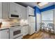 The kitchen has white appliances and cabinets with a window to let in sunlight at 615 Dream Island Pl # 303, Longboat Key, FL 34228