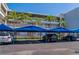 Convenient parking: view of covered parking spaces in front of the building, landscaped with palm trees at 615 Dream Island Pl # 303, Longboat Key, FL 34228