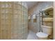 Tiled walk-in shower features a glass block wall, shower head and shelving at 615 Dream Island Pl # 303, Longboat Key, FL 34228