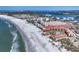 Wide aerial shot showcasing the shoreline, condominiums, and a sandy beach filled with people enjoying the sun at 6236 Midnight Pass Rd # 300, Sarasota, FL 34242