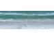 A stunning aerial view of a serene beach with gentle waves lapping the shore and only a few people at 6236 Midnight Pass Rd # 300, Sarasota, FL 34242