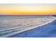 Scenic beach view with gentle waves lapping the shore, and a vibrant sunset sky at 6236 Midnight Pass Rd # 300, Sarasota, FL 34242