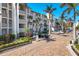 Exterior shot of a condo complex with a brick driveway, lush landscaping, and ample parking at 6236 Midnight Pass Rd # 300, Sarasota, FL 34242