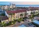 Beautiful condo building with palm trees, exterior staircases, covered parking, and brick paved parking lot at 6236 Midnight Pass Rd # 300, Sarasota, FL 34242