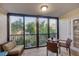 Enclosed lanai with wicker furniture including a sofa and chairs overlooking lush greenery and trees at 6236 Midnight Pass Rd # 300, Sarasota, FL 34242