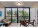 Enclosed lanai with wicker furniture including a sofa and chairs overlooking lush greenery and trees at 6236 Midnight Pass Rd # 300, Sarasota, FL 34242