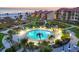 Aerial view of a large outdoor pool with lounge chairs, lush landscaping, and a spa overlooking the beach at 6236 Midnight Pass Rd # 300, Sarasota, FL 34242