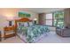 Bedroom featuring a cozy bed with tropical bedding and a window overlooking lush greenery at 6480 Midnight Pass Rd # 316, Sarasota, FL 34242