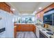 Well-lit kitchen area with granite countertops, wood cabinets, and breakfast bar overlooking the living area at 6480 Midnight Pass Rd # 316, Sarasota, FL 34242