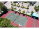 Aerial view of a tennis court surrounded by lush landscaping and palm trees, creating a private recreation space at 6480 Midnight Pass Rd # 316, Sarasota, FL 34242