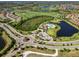Stunning aerial view of a Primary-planned community featuring a pool, clubhouse, golf course and winding roads at 7044 Whittlebury Trl, Bradenton, FL 34202