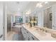 Luxurious bathroom featuring dual sinks, a soaking tub, and a glass-enclosed shower at 7044 Whittlebury Trl, Bradenton, FL 34202