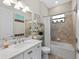Bright bathroom with a marble vanity, neutral tile, and a shower-tub combination at 7044 Whittlebury Trl, Bradenton, FL 34202