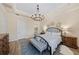 Comfortable bedroom with a decorative chandelier and a cozy bench at the foot of the bed at 7044 Whittlebury Trl, Bradenton, FL 34202