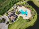 Aerial close up showcases the community pool and clubhouse nestled beside a lake in a scenic neighborhood at 7044 Whittlebury Trl, Bradenton, FL 34202