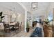 Open-concept dining room with a modern chandelier and water view in the background at 7044 Whittlebury Trl, Bradenton, FL 34202