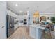 Modern kitchen with stainless steel appliances, white cabinets, and a center island with seating at 7044 Whittlebury Trl, Bradenton, FL 34202