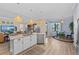 Open kitchen with island bar, stainless appliances, and a view into both the living and dining spaces at 7044 Whittlebury Trl, Bradenton, FL 34202