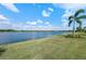 Lakeside view featuring a beautiful lake, lush lawn, and community homes in the background at 7044 Whittlebury Trl, Bradenton, FL 34202