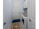 Functional laundry room featuring a washer, dryer, and blue accent wall with white cabinets at 7044 Whittlebury Trl, Bradenton, FL 34202