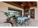 Covered outdoor kitchen and patio featuring wood ceiling, stone accents, stainless grill, and view of the lake at 7044 Whittlebury Trl, Bradenton, FL 34202
