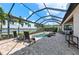 Screened-in pool area with palm trees, view of the lake, patio furniture, and lush landscaping at 7044 Whittlebury Trl, Bradenton, FL 34202