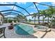 Relaxing screened-in pool area with a spa, scenic lake views, and comfortable seating at 7044 Whittlebury Trl, Bradenton, FL 34202
