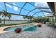 Inviting screened-in pool area with beautiful landscaping and scenic lake views at 7044 Whittlebury Trl, Bradenton, FL 34202