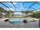 Inviting screened-in pool area with beautiful landscaping and scenic lake views at 7044 Whittlebury Trl, Bradenton, FL 34202