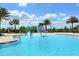 Resort-style pool area featuring a splash pad, lounge chairs, and tropical landscaping at 7044 Whittlebury Trl, Bradenton, FL 34202