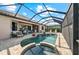 Screened-in pool area featuring a kidney shaped pool, jacuzzi, brick pavers, and covered patio with seating at 7044 Whittlebury Trl, Bradenton, FL 34202