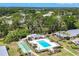 Aerial view showcasing the community pool, shuffleboard courts, mature trees and the surrounding buildings at 7069 W Country Club N Dr # 7069, Sarasota, FL 34243