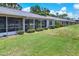 Exterior view of condos with a well-manicured lawn, screened lanais, and lush shrubbery at 7069 W Country Club N Dr # 7069, Sarasota, FL 34243