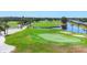 Aerial view of green golf course with sand traps, pond, and mature trees on a sunny day at 7069 W Country Club N Dr # 7069, Sarasota, FL 34243