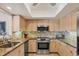 Charming kitchen featuring stone countertops, stainless steel appliances, and ample cabinet space at 7069 W Country Club N Dr # 7069, Sarasota, FL 34243
