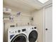 Functional laundry room featuring a washer, dryer, shelving, and a storage closet at 7069 W Country Club N Dr # 7069, Sarasota, FL 34243