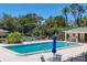 Community pool area, featuring lounge chairs, patio tables, and shade umbrellas at 7069 W Country Club N Dr # 7069, Sarasota, FL 34243