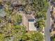 Birds-eye view of home featuring mature trees, concrete driveway and roof in a lush, tropical neighborhood at 717 Treasure Boat Way, Sarasota, FL 34242