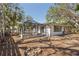 A fenced backyard featuring an enclosed patio with a ceiling fan and a fire pit area for outdoor enjoyment at 717 Treasure Boat Way, Sarasota, FL 34242