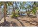 A spacious yard adorned with lots of mature shade trees, a bench, and a charming wrought iron fence at 717 Treasure Boat Way, Sarasota, FL 34242