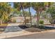 Charming home with a red front door, palm trees, a well-maintained lawn, and a spacious driveway at 717 Treasure Boat Way, Sarasota, FL 34242