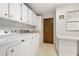 Bright laundry room with white cabinets, side-by-side washer and dryer and window at 717 Treasure Boat Way, Sarasota, FL 34242