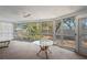A sunroom filled with bright sunlight and lots of large windows showcasing the beautiful backyard at 717 Treasure Boat Way, Sarasota, FL 34242